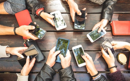 th_820a69-20190409-a-group-of-people-using-smartphones